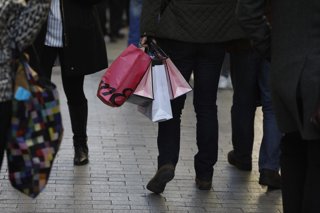 Archivo - Personas caminan por la calle con bolsas de compra, en una imagen de archivo.