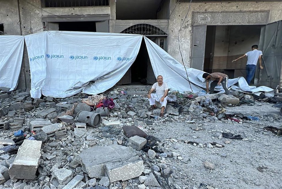 Palestinos entre los restos de una vivienda en Deir al Balá, en la Franja de Gaza, bombardeada por Israel