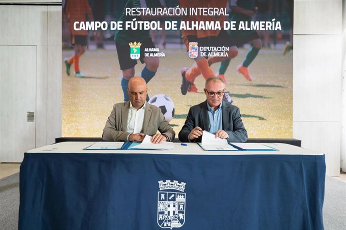 El presidente de la Diputación de Almería, José Antonio García Alcaina, y el alcalde de Alhama de Almería, Cristóbal Rodríguez, durante la firma del convenio para la restauración del campo de fútbol del municipio.