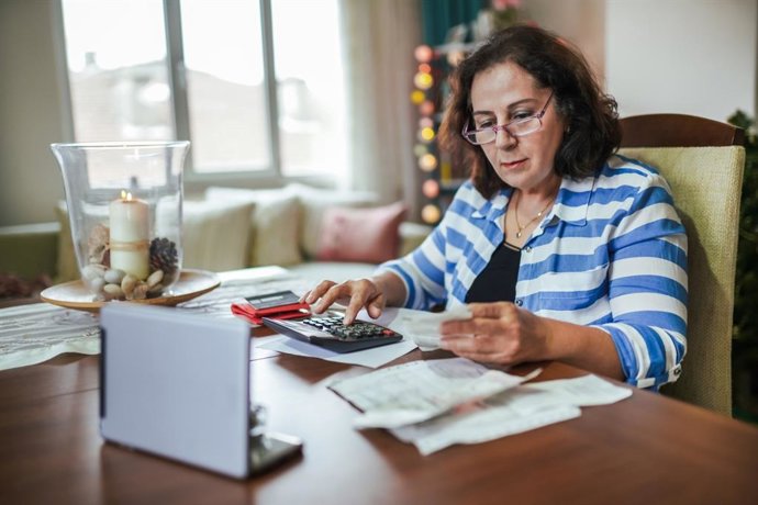 Archivo - Mujer revisando facturas.