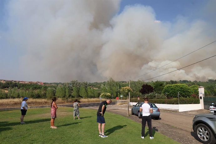 Várias pessoas observam o incêndio, em 29 de julho de 2026, em San Cipriano, León, Castela e Leão (Espanha). Cinco aviões, três helicópteros e sete brigadas do Ministério da Transição Econômica e do Desafio Democrático (Miteco) atuam em quatro i