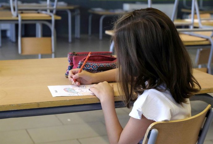 Archivo - Una niña pinta en un colegio. Niña, alumna, colegio, aula, clase.