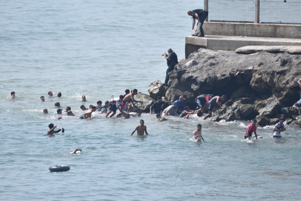 Cientos de personas cruzan a nado a Ceuta desde Marruecos con una multitud esperando al otro lado de la frontera