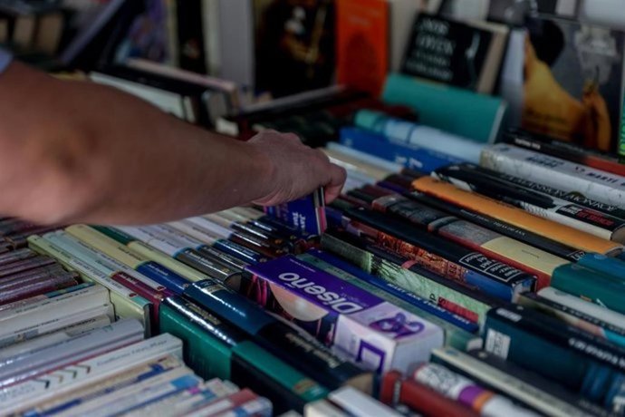 Archivo - Un joven escoge un libro en una librería.