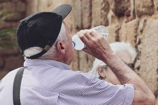 Imagen de archivo de una persona mayor bebiendo agua