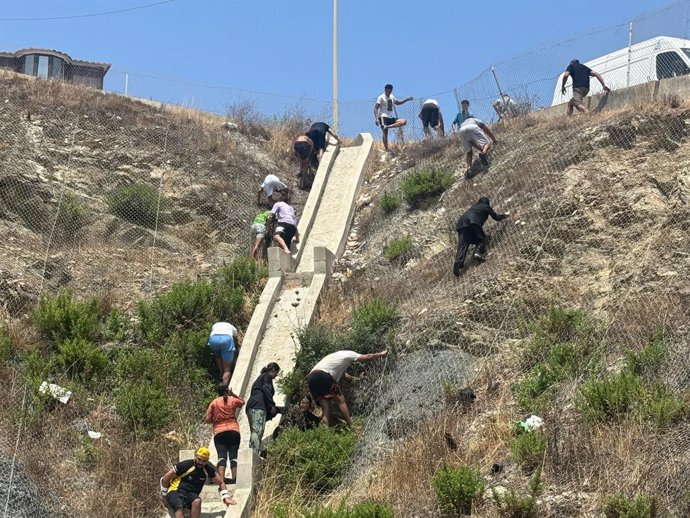Vários migrantes, em 30 de julho de 2026, em Ceuta (Espanha). Centenas de pessoas de origem magrebina cruzaram, ao longo da manhã de hoje, para Ceuta vindas do Marrocos, a nado e pela barreira marítima, e uma multidão aguarda do outro lado da fronteira pa