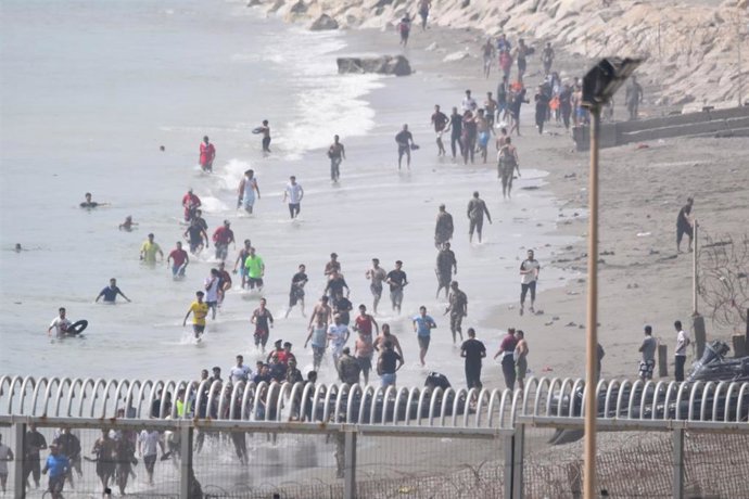 Varios migrantes intentan cruzar la frontera a nado, a 30 de julio de 2026, en Ceuta (España).