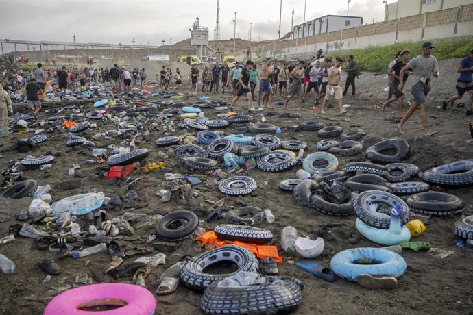 Flotadores y migrantes tras traspasar la frontera entre Ceuta y Marruecos