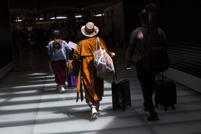 Archivo - Varias personas con maletas en la terminal T4 del Aeropuerto Adolfo Suárez Madrid-Barajas, a 21 de mayo de 2021.