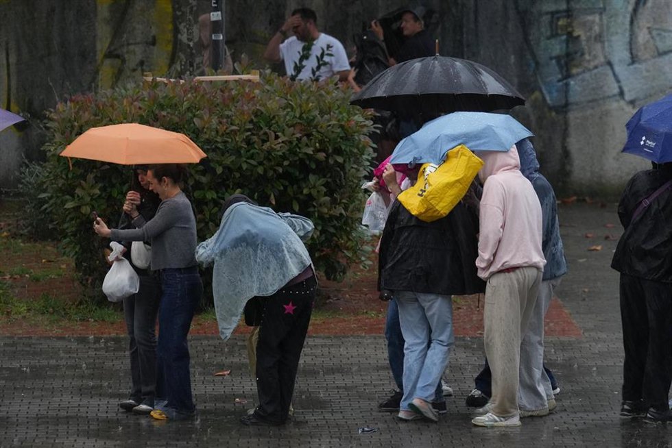 Archivo - Varias personas bajo la lluvia