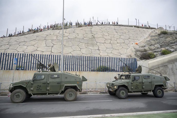 Coches del ejército vigilan la frontera, a 31 de julio de 2026, en Ceuta (España).  La ciudad autónoma de Ceuta ha amanecido con numerosas personas que seguían entrando desde Marruecos a primera hora de esta mañana después de una madrugada en la que la af