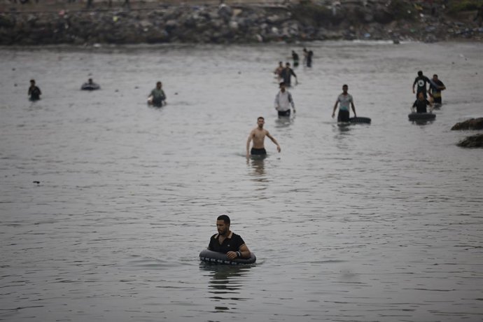 Varios migrantes intentan cruzar a nado la frontera, a 31 de julio de 2026, en Ceuta (España). 