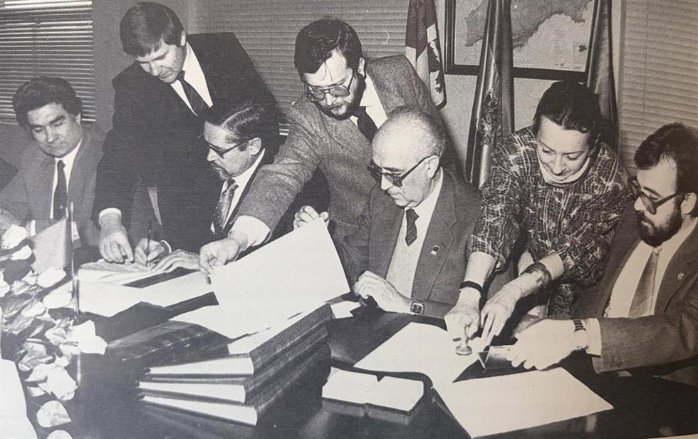 Manuel García Álvarez, en el centro de pie sujetando una hoja, durante una firma de un convenio en la Universidad de León (ULE).