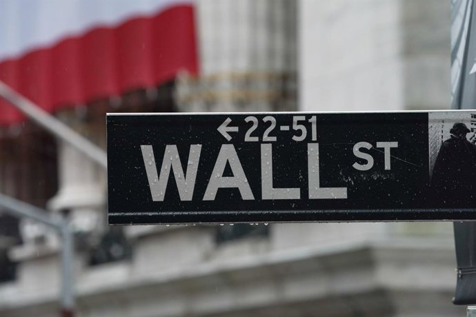 Archivo - Arquivo - 3 de abril de 2020, EUA, Nova York: Uma placa com a inscrição “Wall Street” está pendurada perto da fachada da Bolsa de Valores de Nova York, enquanto as ações caem após os EUA divulgarem dados sobre a perda de empregos em março e em m