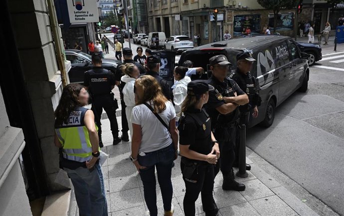 La policía custodia la entrada del piso de Perines mientras la funeraria saca el cuerpo de la víctima, de 27 años. La Policía Nacional ha detenido a su pareja, un hombre de 39, como presunto autor del homicidio, que se investiga como vilencia de género
