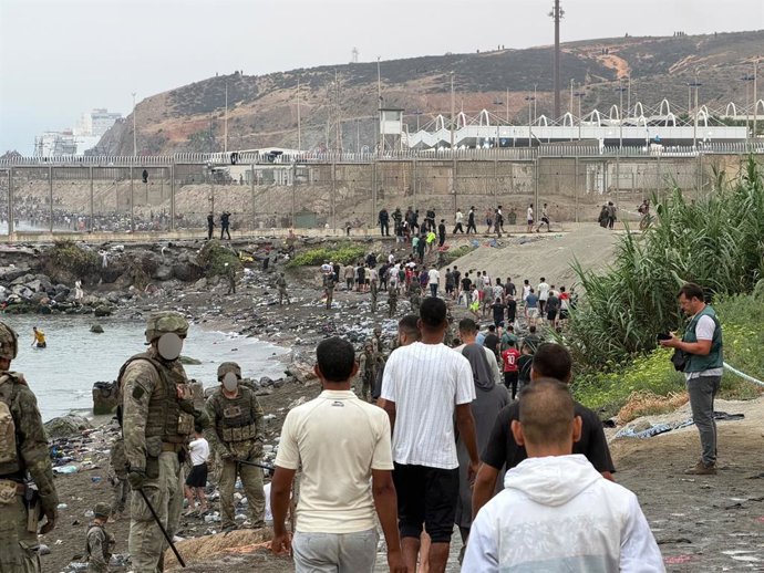 Dezenas de migrantes retornam a pé ao Marrocos, em 31 de julho de 2026, em Ceuta (Espanha). Centenas de pessoas que entraram em Ceuta em massa nas últimas horas estão começando a retornar voluntariamente ao Marrocos pela barreira fronteiriça. 