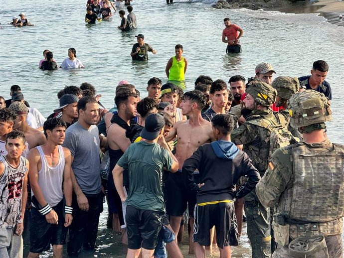 Pessoas que chegam esta tarde a Ceuta vindas do Marrocos e se deparam com os militares que, até às 20h00, estavam posicionados na praia