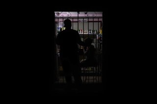 Archivo - Se ve la silueta de un habitante de La Habana frente a una pequeña tienda durante un apagón generalizado que afecta a la capital cubana.