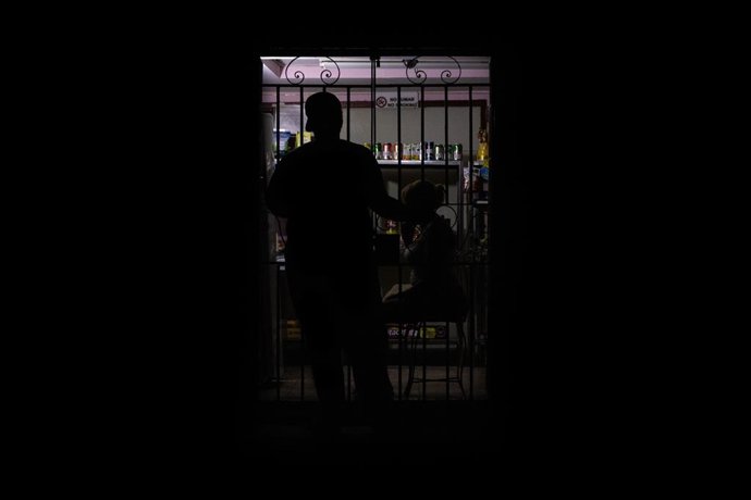 July 14, 2026, Havana, CU: HAVANA, CUBA - JULY 14, 2026: A silhouette of a resident of Havana is seen in front of a small shop during a widespread power outage affecting the Cuban capital. The blackout, Cuba's fifth nationwide electricity collapse of 2026