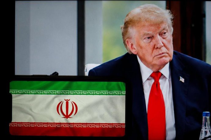 Archivo - Ilustración fotográfica, se ve al presidente de EEUU, Donald Trump, detrás de la bandera de Irán, ambas proyectadas en pantallas