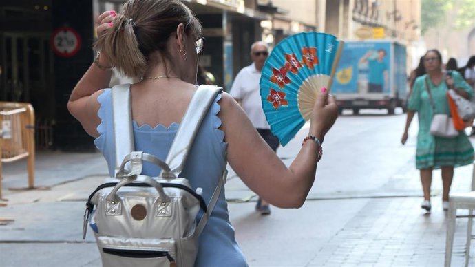 Mujer con abanico por las altas temperaturas