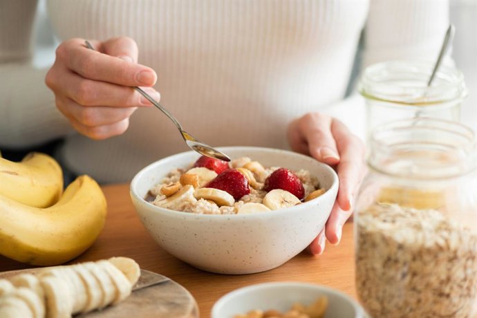 Archivo - Mujer desayunando cereales integrales con fruta y yogur.