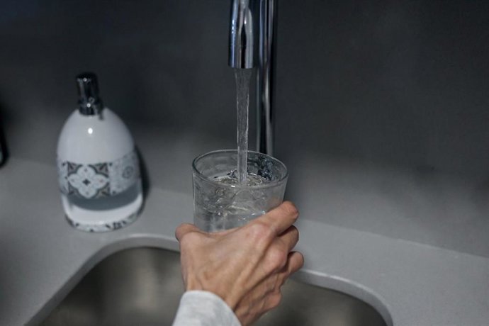 Archivo - Una persona llena un vaso de agua de un grifo
