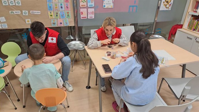 Voluntarios de Cruz Roja con niños hospitalizados.