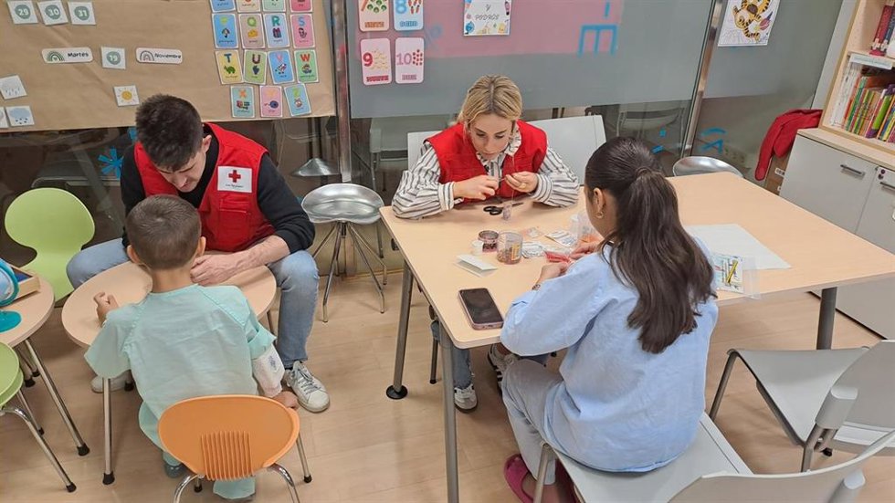 Voluntarios de Cruz Roja con niños hospitalizados.