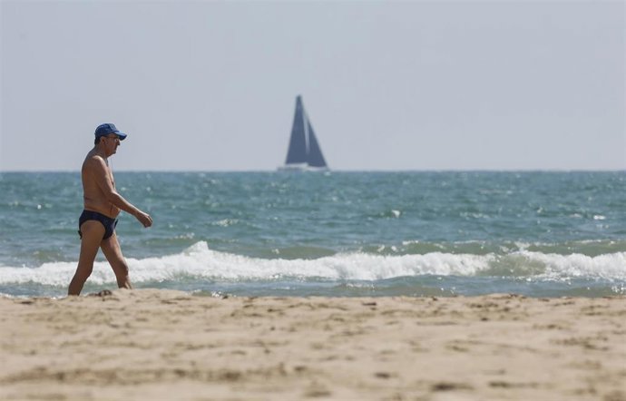 Archivo - Un hombre camina por la playa de la Malvarrosa