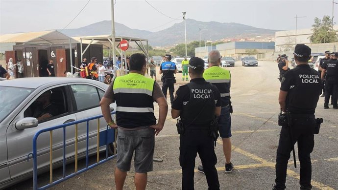 Pasajeros marroquíes de la OPE aguardan en Melilla a pasar a Marruecos mientras los agentes regulan las colas.
