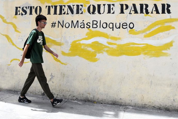 HAVANA, 8 de julho de 2026  -- Um homem passa por uma pichação contra o bloqueio dos EUA, em Havana, capital de Cuba, em 8 de julho de 2026. O ministro das Relações Exteriores de Cuba, Bruno Rodríguez, acusou nesta terça-feira o governo dos EUA de conduzi