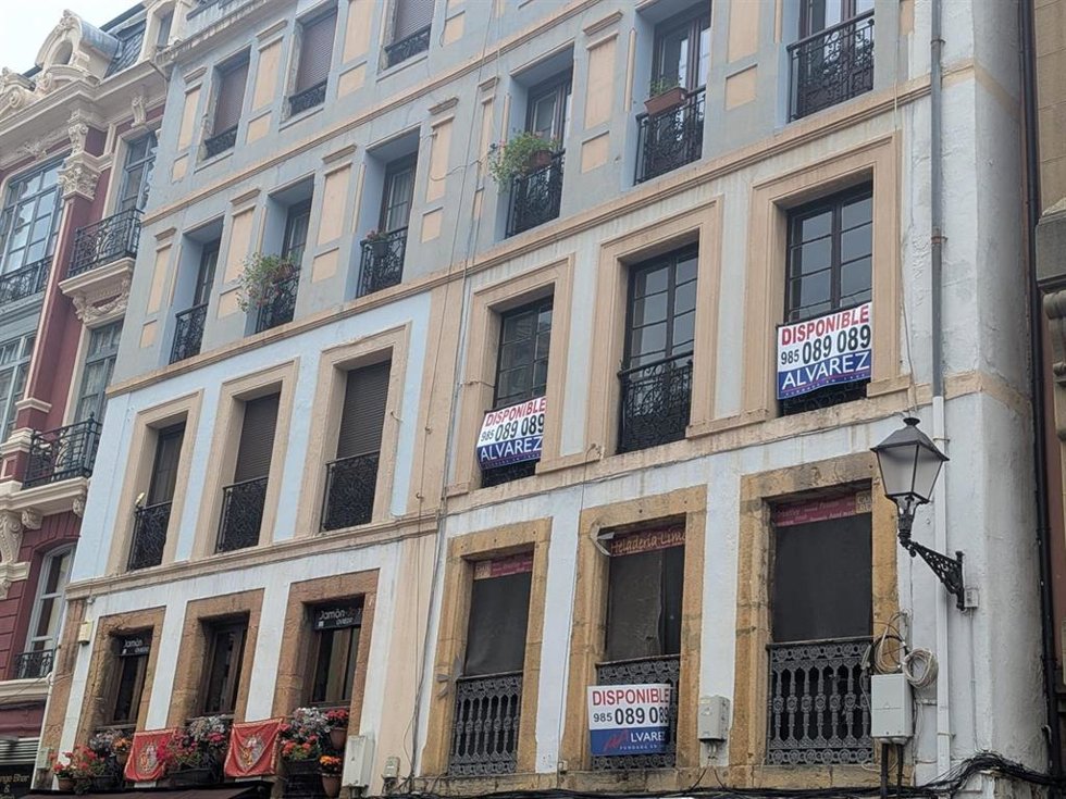 Archivo - Edificio de pisos en Oviedo con varios carteles de venta de viviendas.