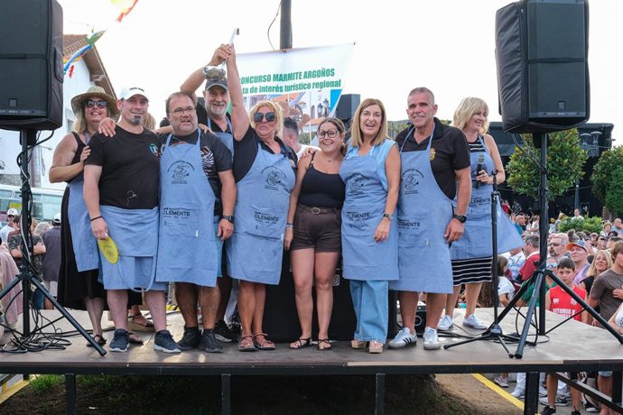La presidenta de Cantabria, María José Sáenz de Buruaga, con el grupo 'El último de la fila', ganador del concurso de marmite de la festividad de San Esteban de Argoños