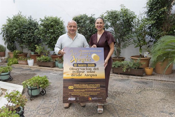 Gabriel Duque muestra el cartel de la actividad, junto a la presidenta de la Asociación de Amigos de Ategua, Guadalupe Morcillo.
