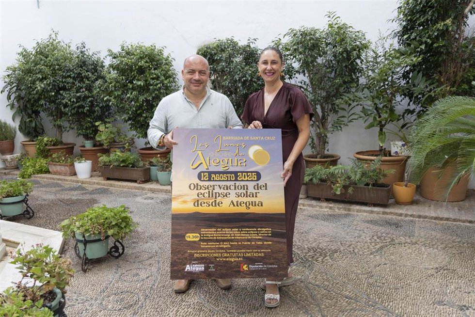 Gabriel Duque muestra el cartel de la actividad, junto a la presidenta de la Asociación de Amigos de Ategua, Guadalupe Morcillo.