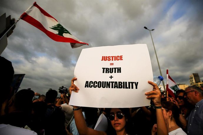 Archivo - Una persona sostiene una pancarta durante una movilización celebrada en Beirut en recuerdo de las víctimas de la explosión de Beirut de 2020.