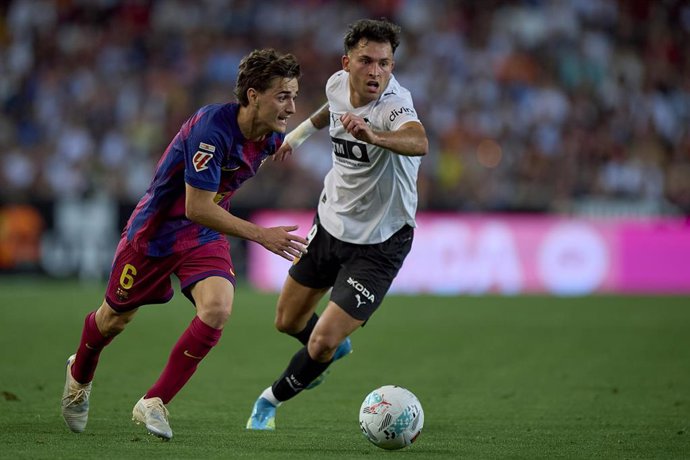 Archivo - El delantero del Valencia CF Hugo Duro (derecha) intenta robar el balón al centrocampista del FC Barcelona Pablo Páez Gavira 'Gavi', en el partido de LaLiga EA Sports 2026-27 disputado en Mestalla.
