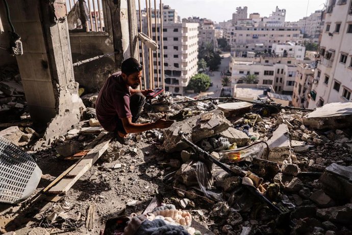 Un palestino inspecciona los escombros tras un ataque aéreo israelí contra un apartamento en la ciudad de Gaza
