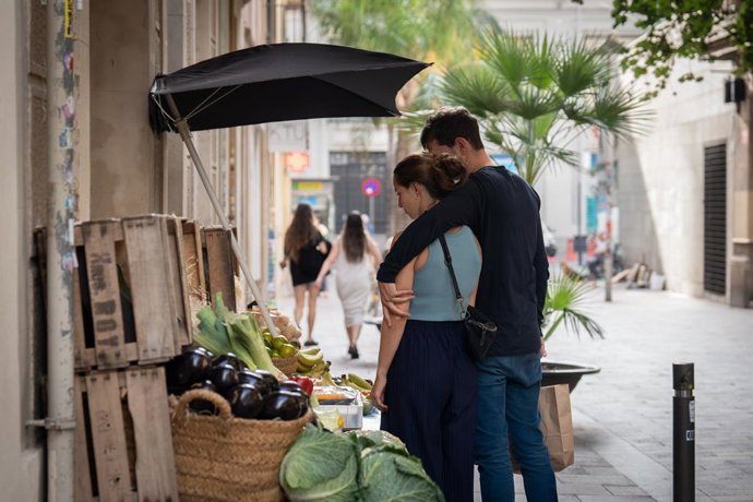Archivo - Arxiu - Dos joves es paren enfront d'una frutería a Barcelona