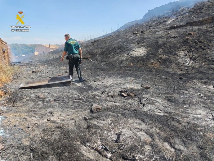 Un agente, en el lugar del incendio provocado por el detenido.