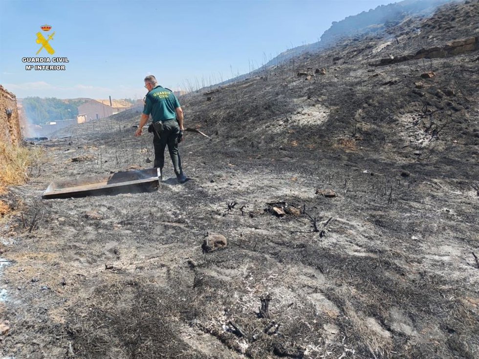 Un agente, en el lugar del incendio provocado por el detenido.