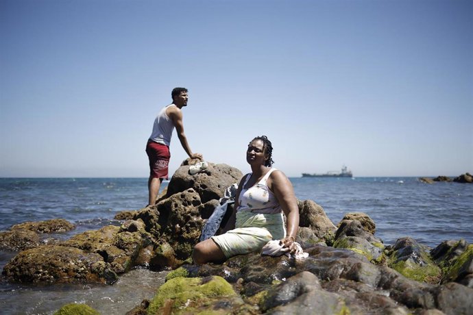 Un hombre y una mujer migrante en la playa, a 2 de agosto de 2026, en Ceuta (España).