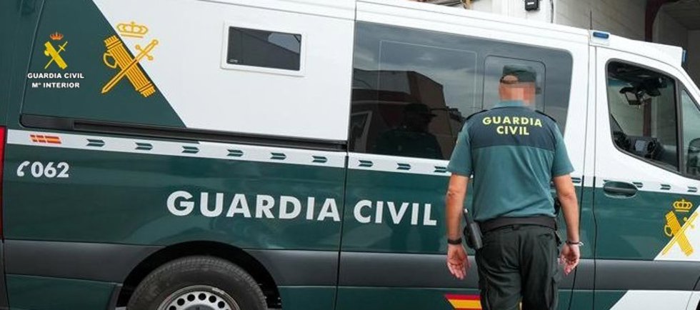 Un agente de la Guardia Civil junto a un vehículo oficial.