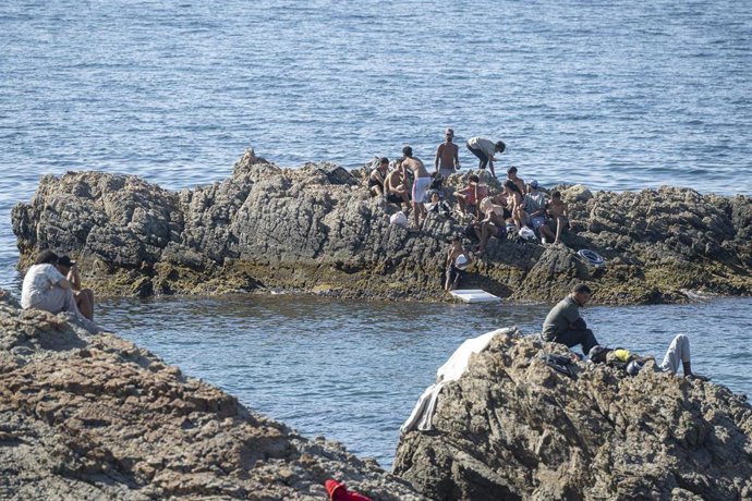 Varias personas migrantes nadando hacia la frontera con Ceuta. 2 de agosto de 2026, en Ceuta (España). 