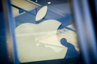 Archivo - FILED - 01 November 2013, Hamburg: A man sits next to the Apple logo which is reflected on a facade of the Apple store in Hamburg. Today, Monday, the Technology company Apple announced that the "App Store" currently supports 250,000 jobs in Germ