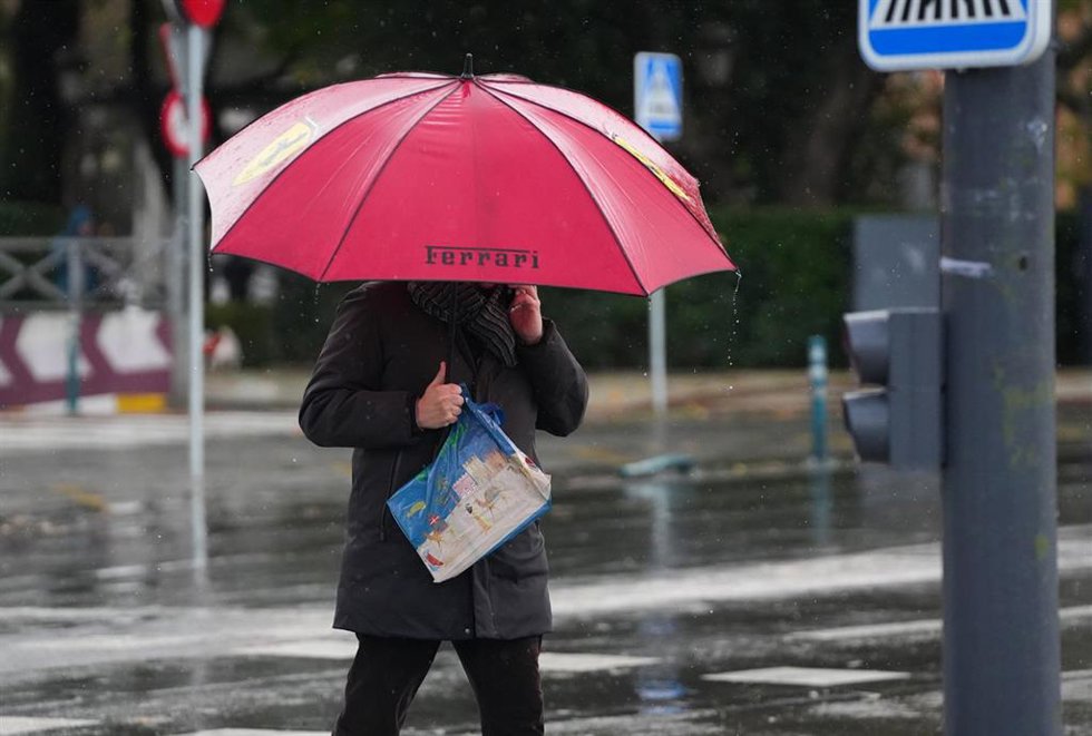 Archivo - Peatones se protegen de la lluvia 
