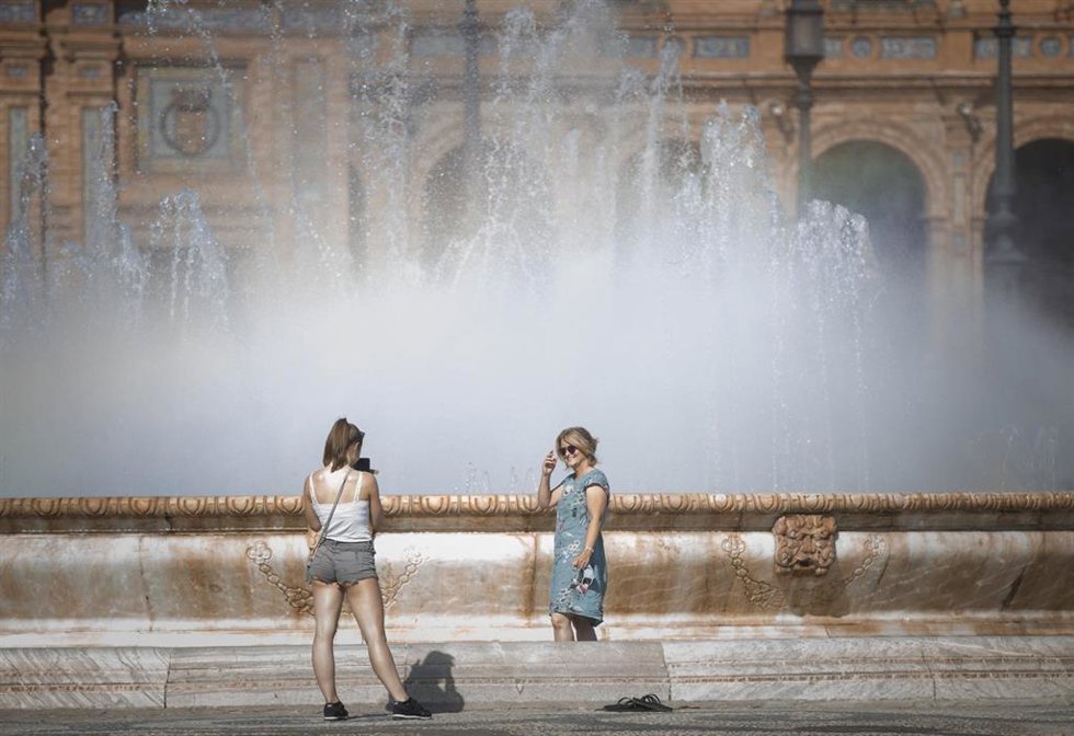 Archivo - Una mujer posa para una foto dentro de la fuente de la Plaza de España. Imagen de archivo. 