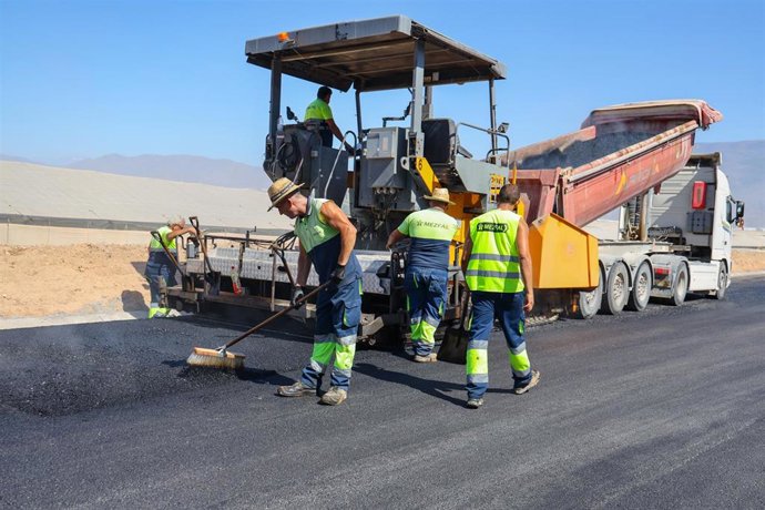 Operarios durante los trabajos de asfaltado del Camino del Mancha, en El Ejido (Almería).