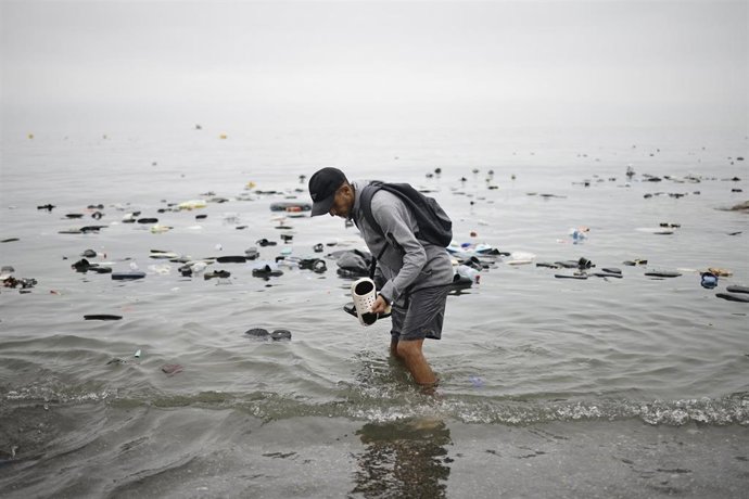 Un hombre recoge unas chanclas del agua, a 31 de julio de 2026, en Ceuta (España).  